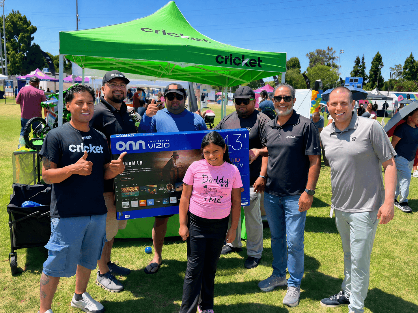NKB event team and community members gathered under a Cricket tent